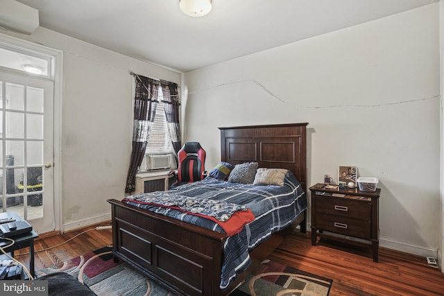 bedroom with cooling unit and dark wood-type flooring