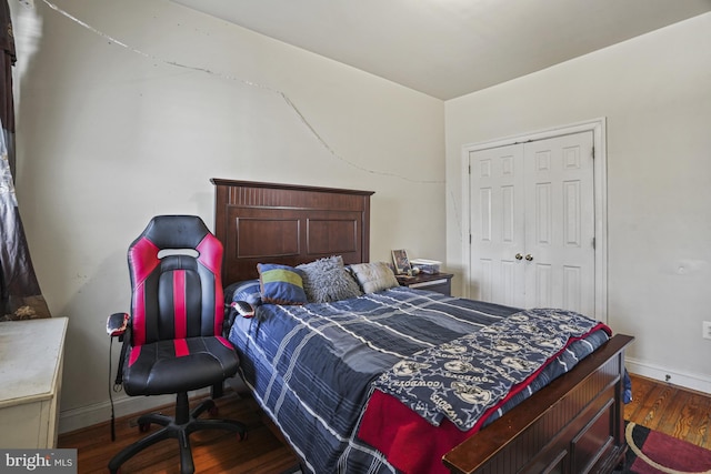 bedroom with dark hardwood / wood-style flooring and a closet