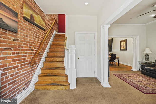 stairway featuring crown molding, carpet floors, and brick wall