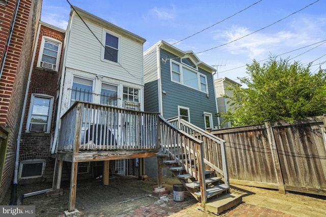 rear view of house featuring cooling unit and a wooden deck