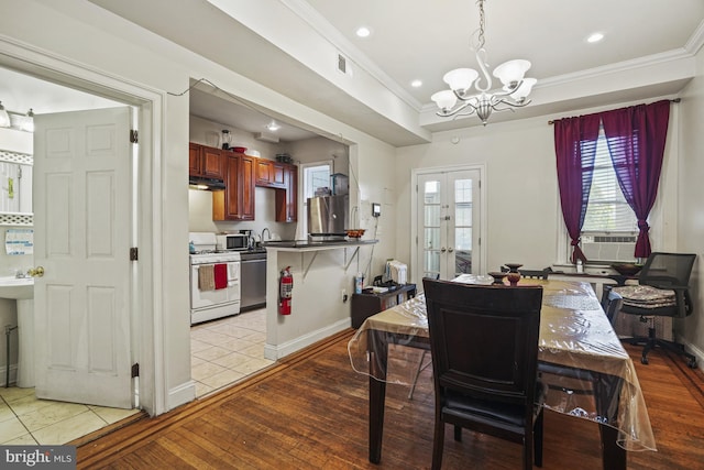 dining space with a chandelier, french doors, light hardwood / wood-style floors, and cooling unit