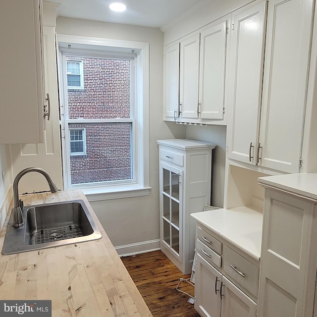 kitchen with white cabinets, dark hardwood / wood-style flooring, and sink