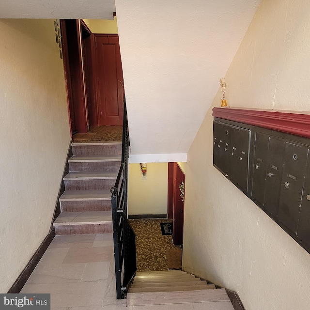 staircase featuring a mail area