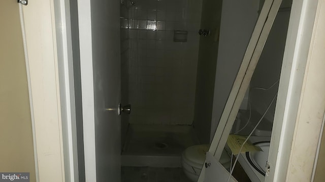 bathroom with toilet and a tile shower