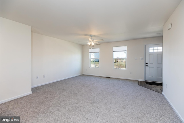 unfurnished living room featuring light carpet and ceiling fan