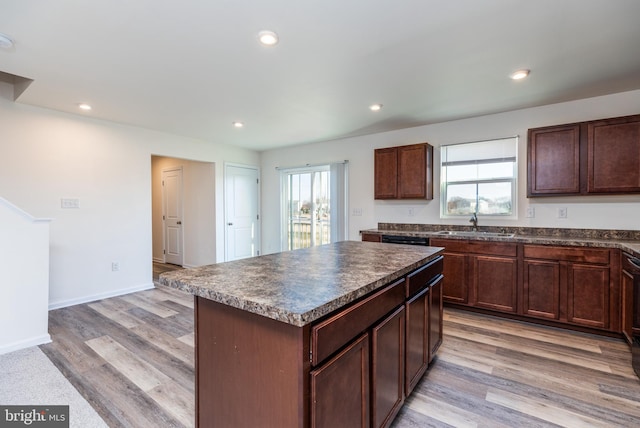 kitchen featuring sink, a kitchen island, a healthy amount of sunlight, and light hardwood / wood-style flooring