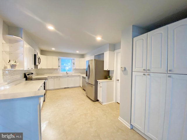 kitchen featuring white cabinets, stainless steel appliances, backsplash, and sink