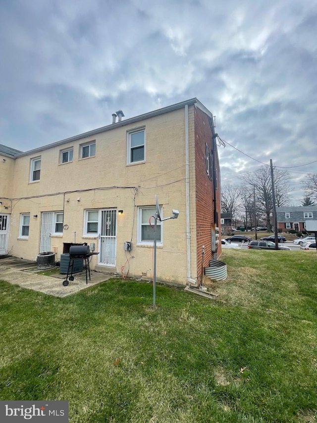 rear view of house featuring a yard, a patio area, and central air condition unit