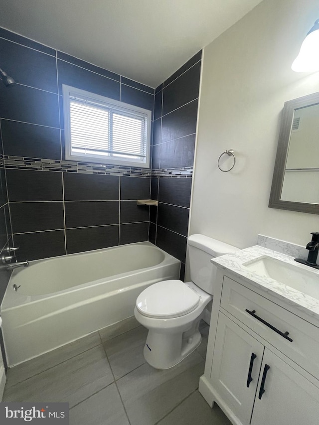 full bathroom featuring tile patterned floors, vanity, toilet, and tiled shower / bath