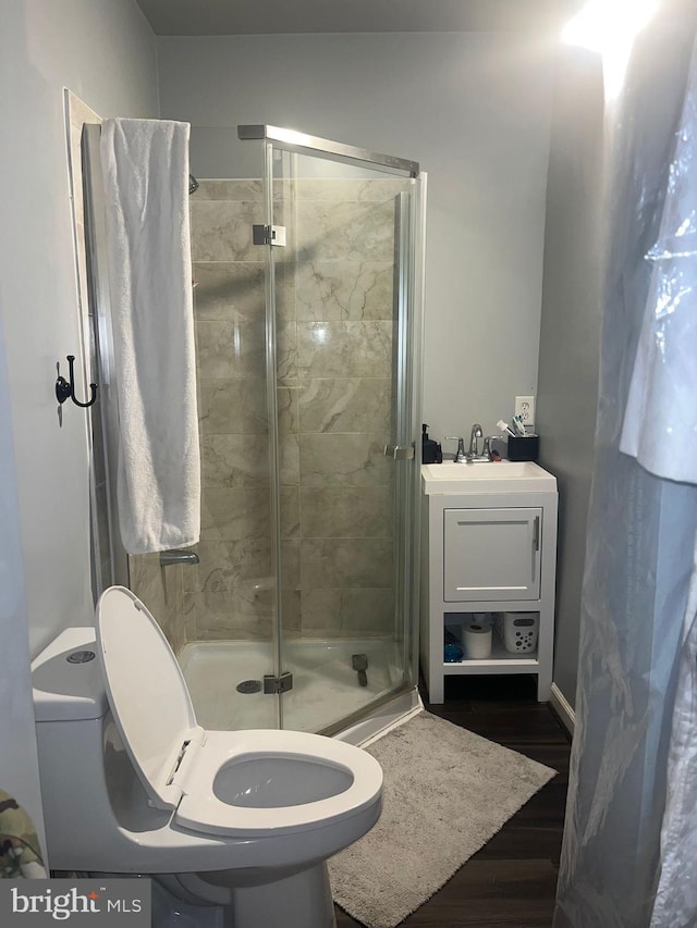 bathroom featuring toilet, sink, wood-type flooring, and walk in shower