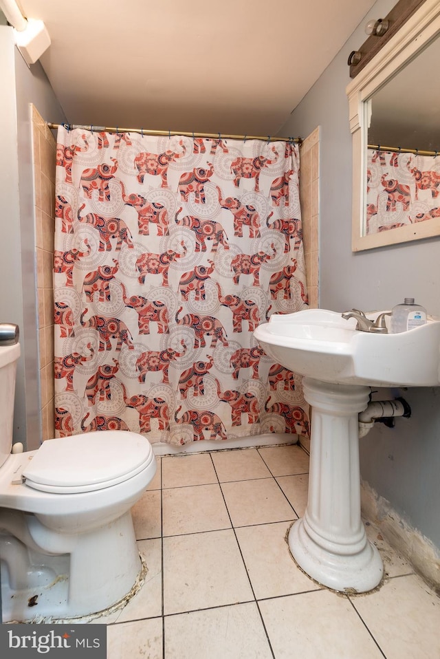 bathroom with tile patterned flooring, a shower with curtain, and toilet