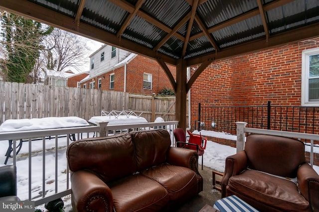 snow covered patio with outdoor lounge area and a gazebo