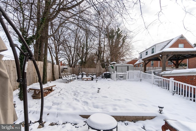 yard covered in snow featuring a storage shed