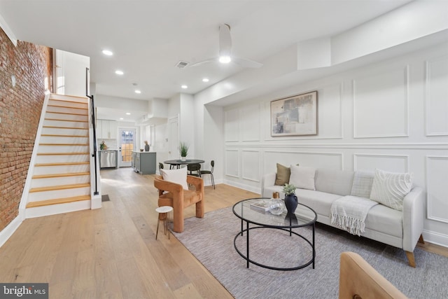 living room featuring light wood-type flooring and brick wall