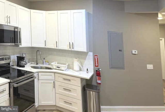 kitchen with sink, stainless steel appliances, white cabinets, and electric panel