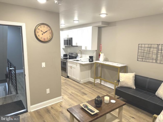 living room with sink and light hardwood / wood-style flooring