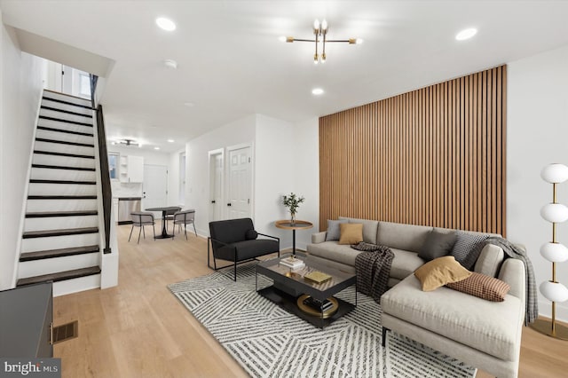 living room featuring a chandelier and light wood-type flooring