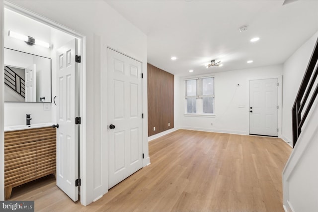 corridor with light hardwood / wood-style flooring and sink