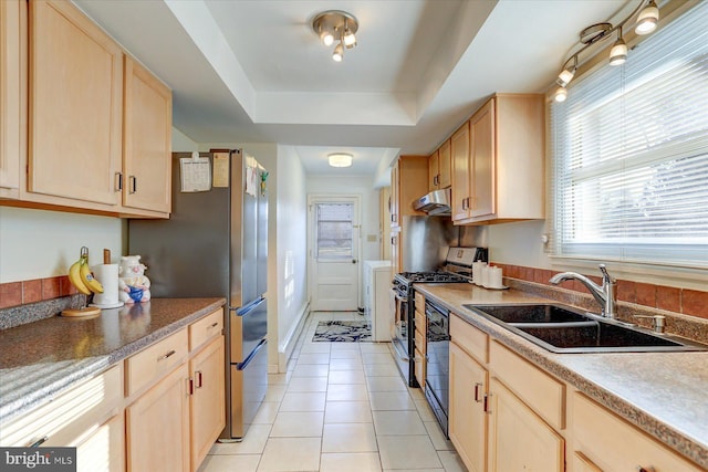 kitchen featuring sink, a raised ceiling, stainless steel gas range oven, light brown cabinetry, and light tile patterned flooring