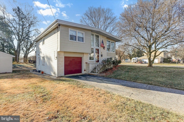 raised ranch with a garage and a front lawn