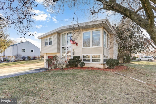 split foyer home with a garage and a front yard