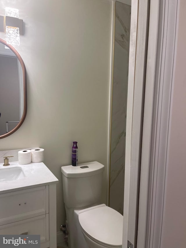 bathroom featuring vanity, toilet, and a shower