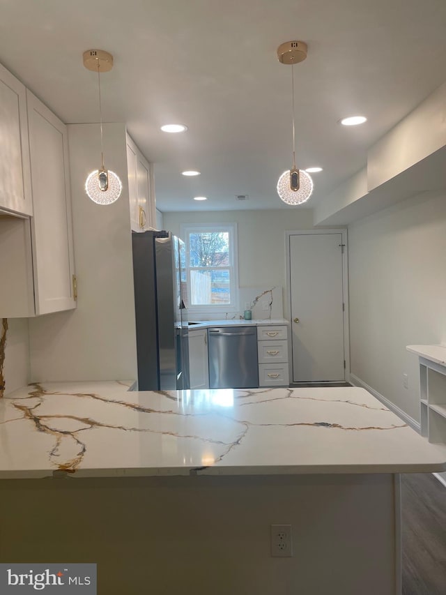 kitchen with kitchen peninsula, hanging light fixtures, white cabinets, and stainless steel appliances