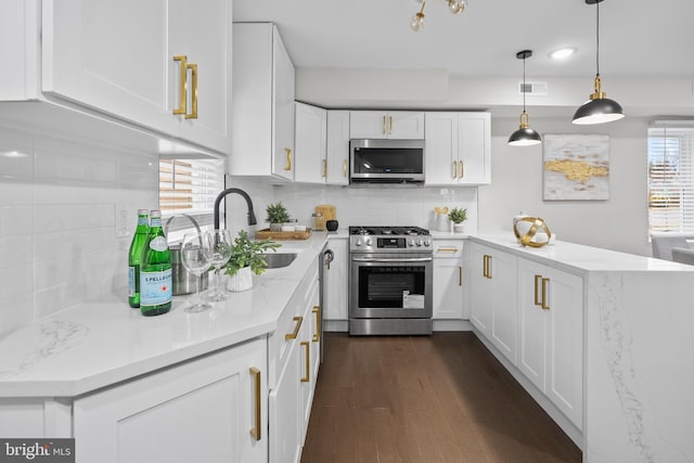 kitchen featuring backsplash, stainless steel appliances, pendant lighting, white cabinets, and dark hardwood / wood-style floors