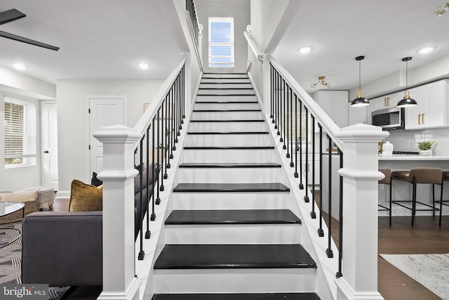 staircase with a wealth of natural light and hardwood / wood-style floors