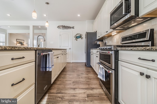 kitchen featuring pendant lighting, white cabinets, stainless steel appliances, and dark hardwood / wood-style floors