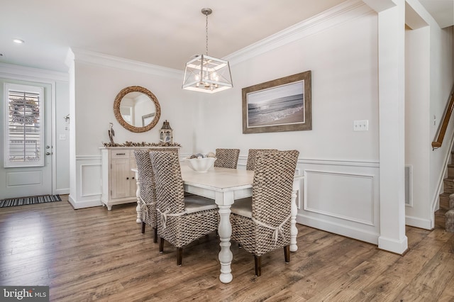 dining area featuring crown molding, a chandelier, and hardwood / wood-style flooring