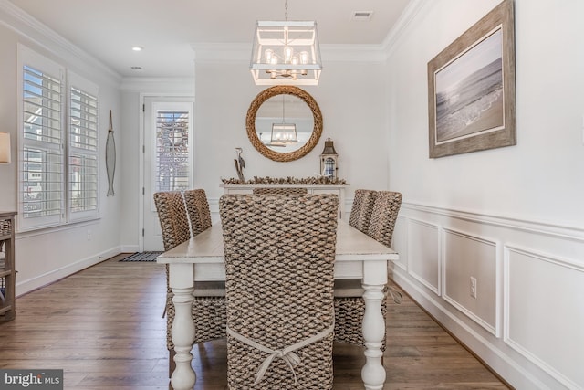 dining space featuring a notable chandelier, crown molding, and dark wood-type flooring