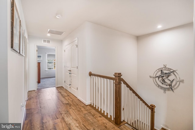 corridor with hardwood / wood-style flooring