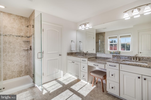 bathroom featuring a shower with door and vanity