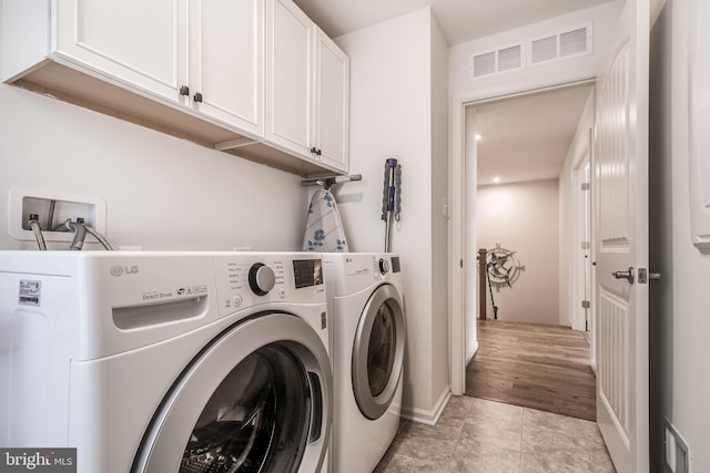 laundry area with cabinets and washer and clothes dryer