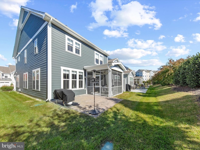 back of house featuring a patio, a lawn, and a sunroom