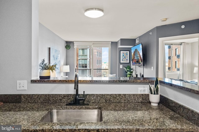 kitchen featuring sink and dark stone counters