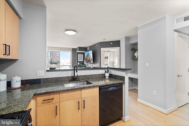 kitchen featuring sink, dark stone counters, light brown cabinets, and black dishwasher