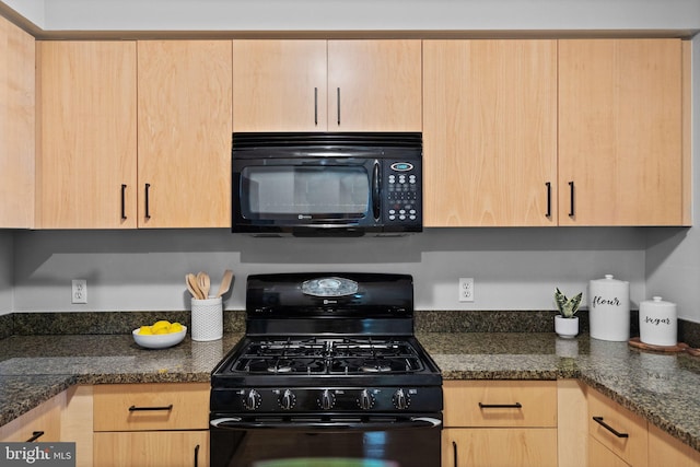 kitchen featuring dark stone counters, light brown cabinetry, and black appliances