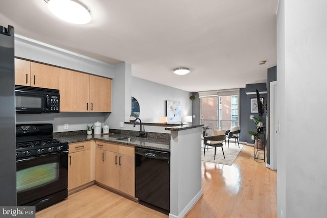 kitchen with black appliances, light brown cabinets, kitchen peninsula, and sink