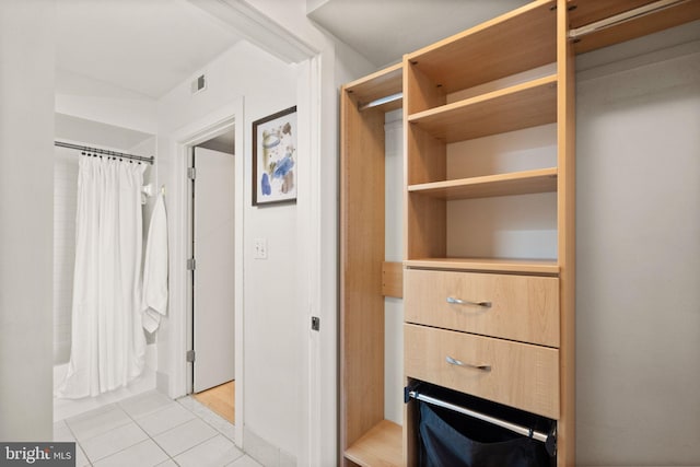 walk in closet with light tile patterned floors