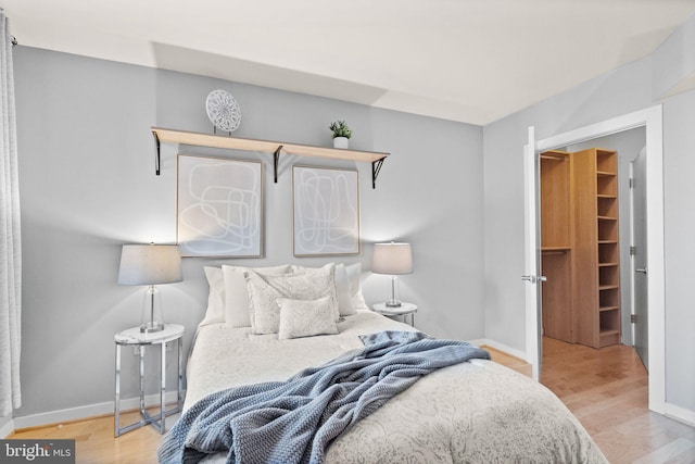 bedroom featuring hardwood / wood-style floors, a spacious closet, and a closet