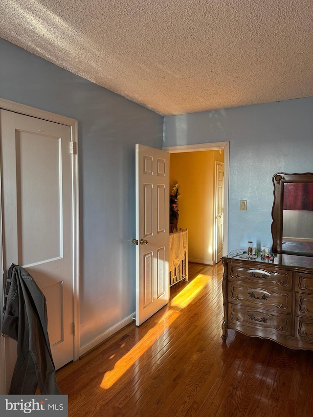 bedroom with wood-type flooring and a textured ceiling