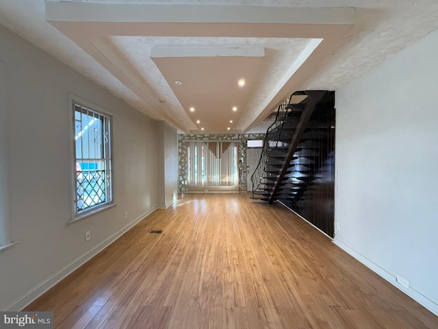 interior space featuring wood-type flooring and a raised ceiling