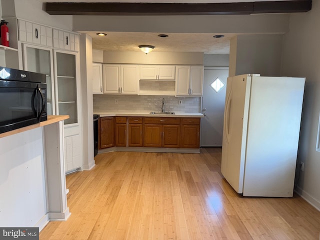 kitchen featuring beam ceiling, sink, white refrigerator, backsplash, and white cabinets