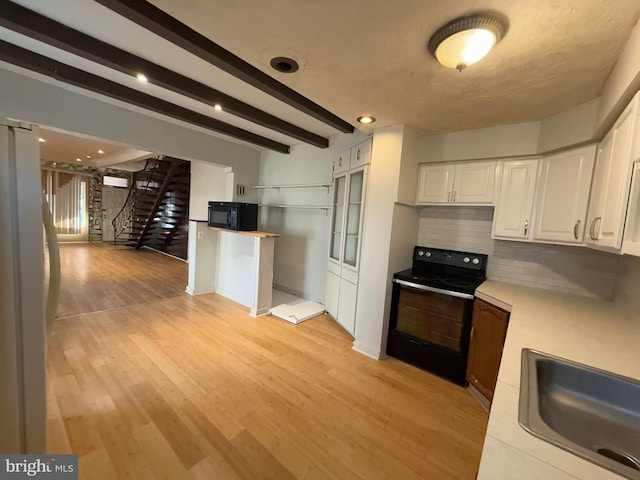 kitchen featuring backsplash, black appliances, beam ceiling, light hardwood / wood-style flooring, and white cabinetry