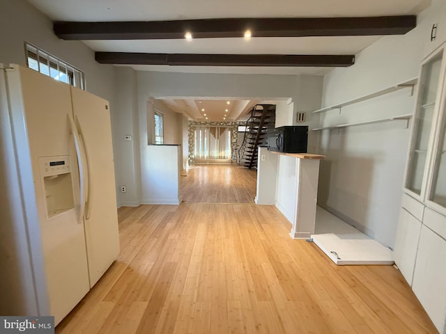 hallway with beamed ceiling, a healthy amount of sunlight, and light hardwood / wood-style flooring