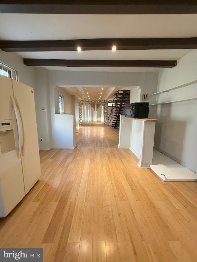 kitchen featuring beamed ceiling, light wood-type flooring, white refrigerator with ice dispenser, and white cabinets