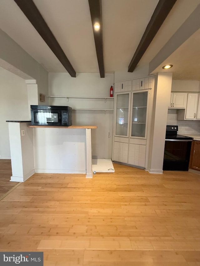 kitchen featuring white cabinetry, light hardwood / wood-style flooring, beamed ceiling, black electric range oven, and decorative backsplash