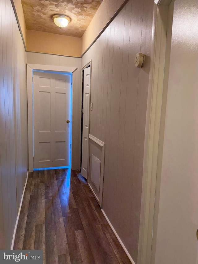 hall featuring wood walls and dark wood-type flooring